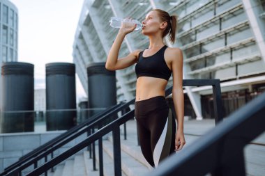 Spor kıyafetli genç bir kadın sabahları dışarıda egzersiz yapıyor. Spor, aktif yaşam, spor eğitimi, sağlıklı yaşam tarzı..