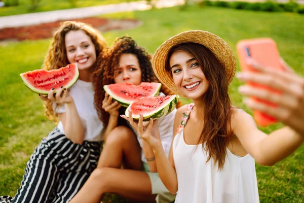 Tři Mladé Ženy Odpočívají Trávě Jedí Meloun Telefonují Selfie Letní — Stock fotografie