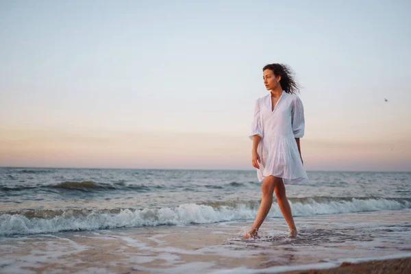 日落时在海滩上散步的漂亮女人 夏天的时候旅行 放松和生活方式概念 — 图库照片
