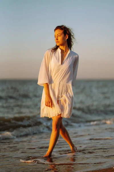 日落时在海滩上散步的漂亮女人 夏天的时候旅行 放松和生活方式概念 — 图库照片