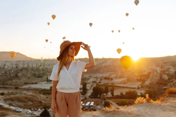 Young Woman Stands Mountain Flying Air Balloons Background Famous Tourist — Stockfoto