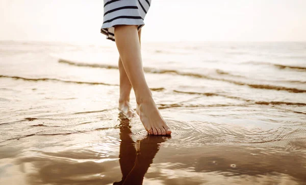 stock image Woman leg close up walking on sand relaxing in beach at sunset. Sexy lean and tanned legs. Summer holidays.