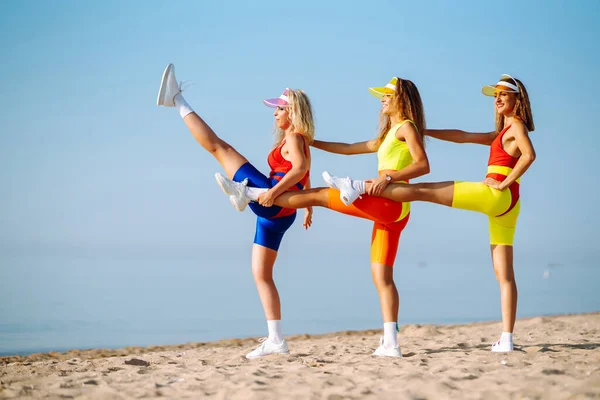 身穿五颜六色泳衣的快乐女人早上在海滩上跳舞 有氧运动除外 积极运动 — 图库照片