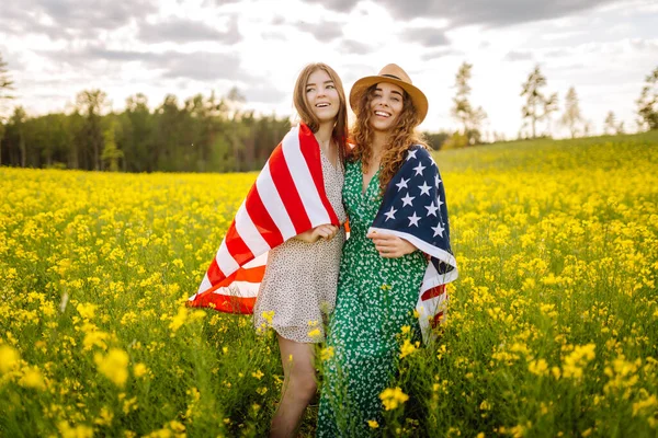 Due Giovani Donne Con Bandiera Americana Sul Prato Fiorito Luglio — Foto Stock
