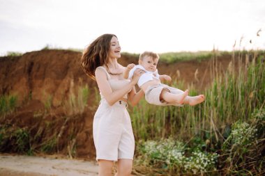 Çocuklu bir anne kumsalda eğleniyor. Aile, çocukluk, aktif yaşam tarzı konsepti.