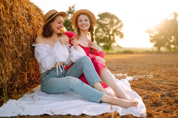 两名妇女躺在靠近干草包的麦田上 放松和生活方式 夏季风景 — 图库照片