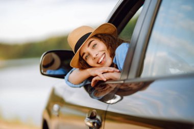 Towards adventure! Young woman is resting and enjoying the trip in the car. Lifestyle, travel, tourism, nature, active life.