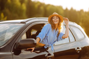 Towards adventure! Young woman is resting and enjoying the trip in the car. Lifestyle, travel, tourism, nature, active life.