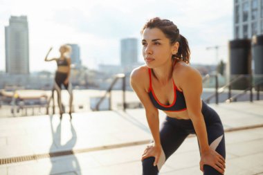 Spor elbiseli iki kadın dışarıda spor günü yapıyorlar. Spor, aktif yaşam, spor eğitimi, sağlıklı yaşam tarzı..