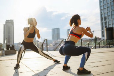 Spor elbiseli iki kadın dışarıda spor günü yapıyorlar. Spor, aktif yaşam, spor eğitimi, sağlıklı yaşam tarzı..