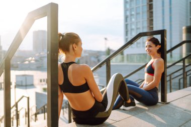 Spor elbiseli iki kadın dışarıda spor günü yapıyorlar. Spor, aktif yaşam, spor eğitimi, sağlıklı yaşam tarzı..