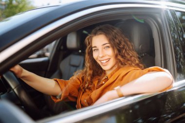 Gülümseyen kadın araba kullanıyor. Araba kullanan genç bir gezgin. Araba yolculuğu, yaşam tarzı konsepti..