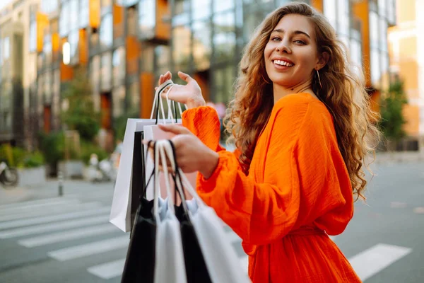 带着购物袋的时髦女人穿过城市的街道 消费主义 生活方式概念 — 图库照片