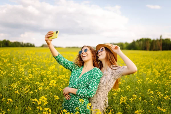 Selfie Zamanı Çiçek Tarlasında Yürürken Iki Genç Kadın Selfie Çekiyor — Stok fotoğraf