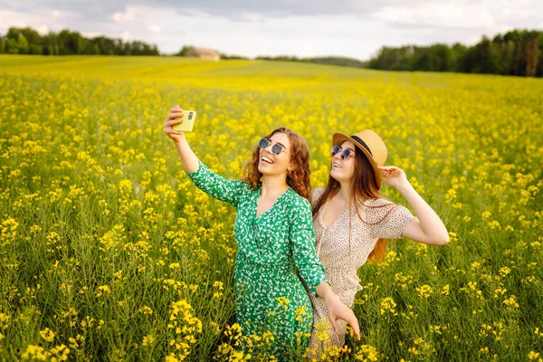 Selfie Zamanı Çiçek Tarlasında Yürürken Iki Genç Kadın Selfie Çekiyor — Stok fotoğraf