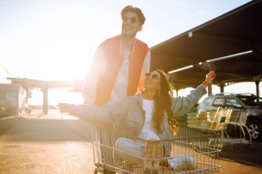 Neşeli çift bir arabaya binip dinleniyor. Genç arkadaşlar gün batımında at arabalarında eğleniyorlar. Tüketim, aktif yaşam tarzı kavramı.