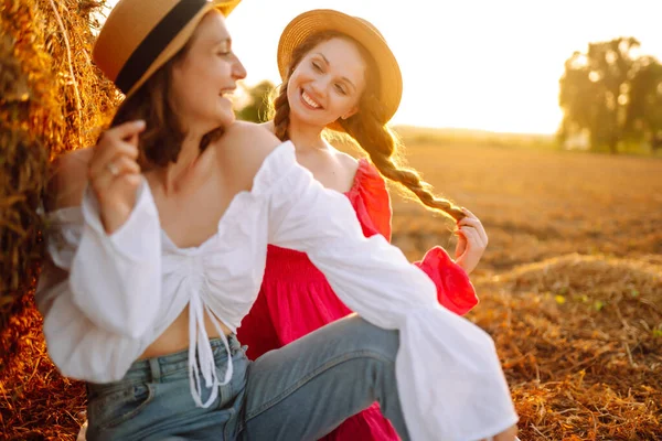 Красивые Две Женщины Веселятся Стоге Сена Закате Стильные Девушки Шляпах — стоковое фото