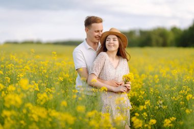 Birbirine aşık genç bir çift kolza tohumu tarlasında yürüyor. Mutlu erkekler ve kadınlar birlikte vakit geçirmenin tadını çıkarıyorlar. Aşk, test, ilişki kavramı.