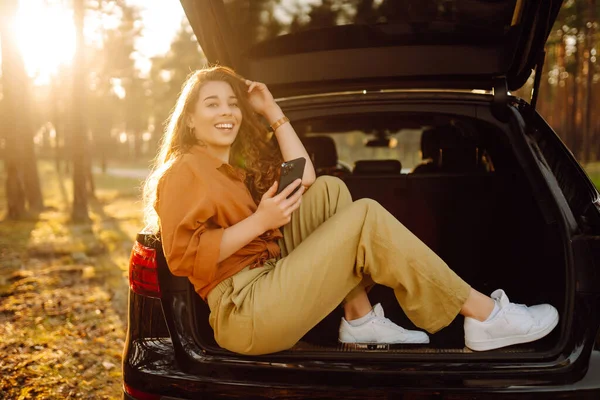 Beautiful Woman Sits Trunk Car Forest Uses Smartphone Concept Traveling — Stock Photo, Image