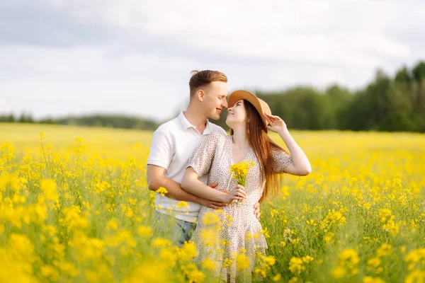 Młoda Zakochana Para Przechodzi Przez Pole Rzepaku Szczęśliwi Mężczyźni Kobiety — Zdjęcie stockowe