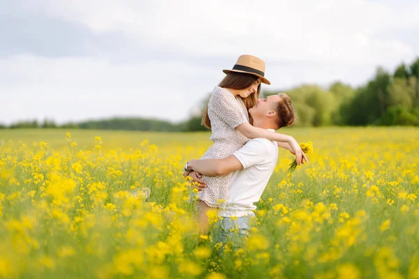 恋のカップルは菜種畑を歩く 幸せな男性と女性のスタイルで一緒に過ごした時間をお楽しみください テスト 関係の概念 — ストック写真