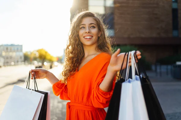 Uśmiechnięta Kobieta Niosąca Torby Zakupy Słoneczny Dzień Konsumpcjonizm Zakupy Zakupy — Zdjęcie stockowe