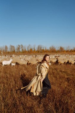 Tarlada poz veren zarif genç bir kadın. Moda, cazibe, yaşam tarzı konsepti. Sonbahar.