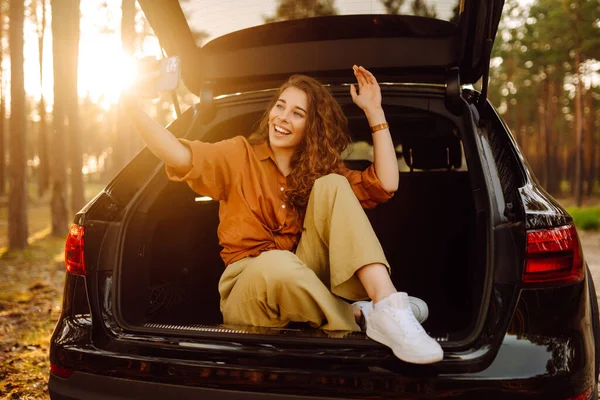 Жінка Відпочиває Багажнику Автомобіля Телефоном Щасливий Туристичний Чат Через Відеодзвінок — стокове фото
