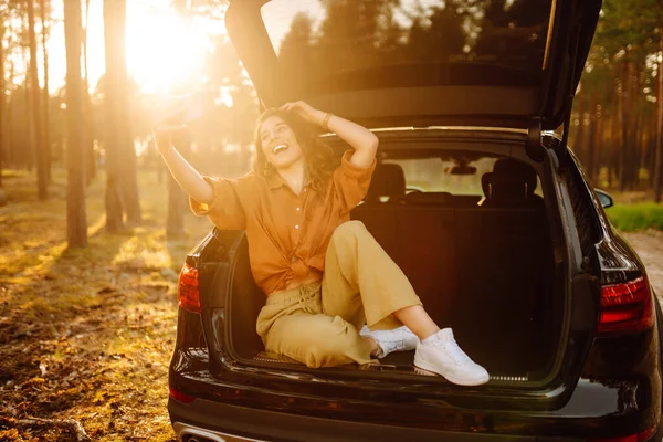 Жінка Відпочиває Багажнику Автомобіля Телефоном Щасливий Туристичний Чат Через Відеодзвінок — стокове фото