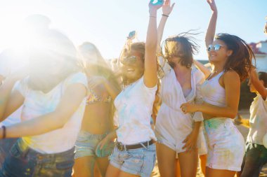 Renkli kıyafetleri ve vücutları olan neşeli genç arkadaşlar Holi Festivali 'nde size iyi eğlenceler. Plaj partisi. Arkadaşlık, dinlenme, tatil.