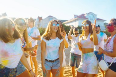 Renkli kıyafetleri ve vücutları olan neşeli genç arkadaşlar Holi Festivali 'nde size iyi eğlenceler. Plaj partisi. Arkadaşlık, dinlenme, tatil.