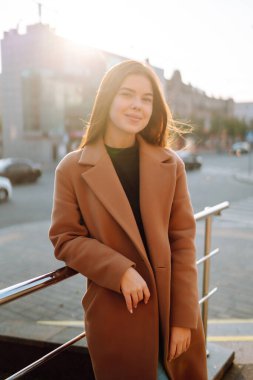 Güneşli bir günde şık, güler yüzlü bir kadın güzel havanın tadını çıkararak şehirde dolaşıyor. Aktif yaşam tarzı, hafta sonları, seyahat