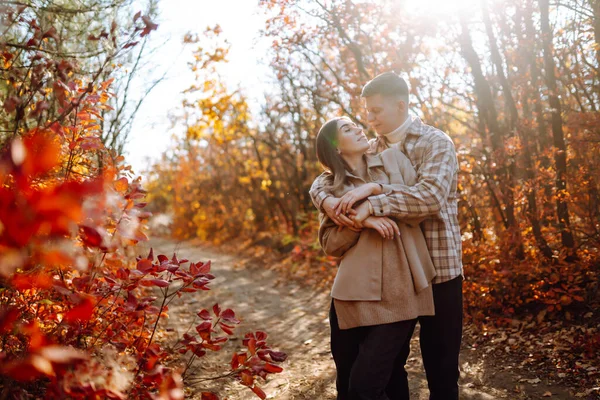快乐与年轻夫妇在美丽的秋天公园散步 享受美丽的天气 怀孕的夫妇在大自然中一起休息 生活方式概念 — 图库照片
