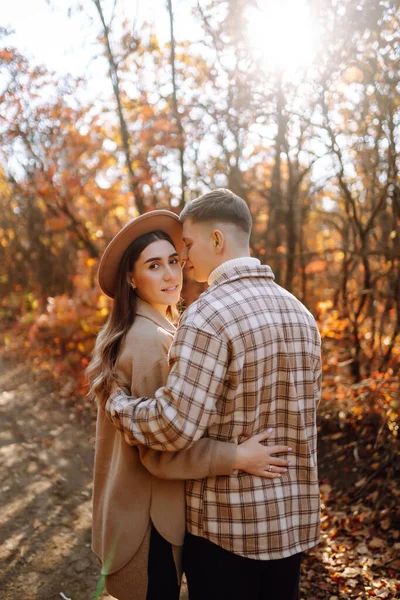幸せで若いカップルは美しい秋の公園を散歩し 美しい天気を楽しんでいます 妊娠した夫婦は自然の中で一緒に休んでいます バケーション ライフスタイルコンセプト — ストック写真