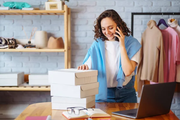 stock image Clothing store: young happy woman, small business owner, seller using tablet checks and packs orders of online store, e-commerce. Online sales.