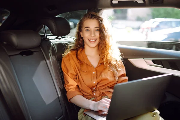 拥有现代笔记本电脑的商业美女坐在汽车后座上 成功的创业 远程工作 自由职业 — 图库照片