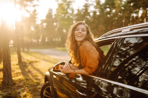 在美丽阳光明媚的夏日路上感受自由 在开车的时候被一个漂亮的女人从车窗里探了出来 积极的生活方式 — 图库照片