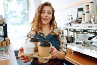 Parlak elbiseli mutlu genç manken şehir manzarasına karşı poz veriyor. Kıvırcık kadın şehrin güzel güneşli havasının tadını çıkarıyor. Yaşam tarzı konsepti. Sokaktaki fotoğraf..