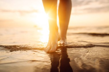 Yaz plajında denizde yürüyen genç bir kadın bacağı. İnce bacaklar. Tatil, seyahat, özgürlük kavramı..