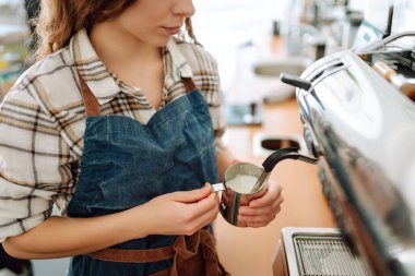 Taze kahve yapan genç bir baristanın portresi. Paket yemek. Profesyonel kahve yapma. Küçük işletme kavramı.