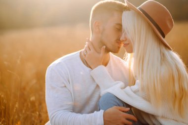 Şık elbiseli mutlu çift birlikte yürür, güneşli sonbahar havasının tadını çıkarırlar. Birlikte vakit geçirin. Dinlenme kavramı, rahatlama..