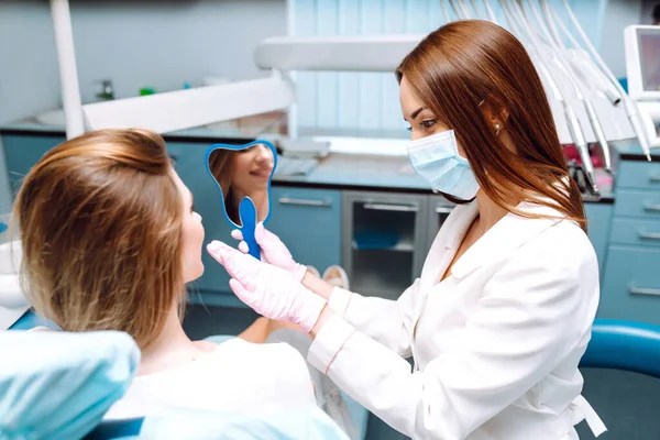 Professional woman dentist is working. Woman patient during a dental procedure. Dental care. Overview of caries prevention.