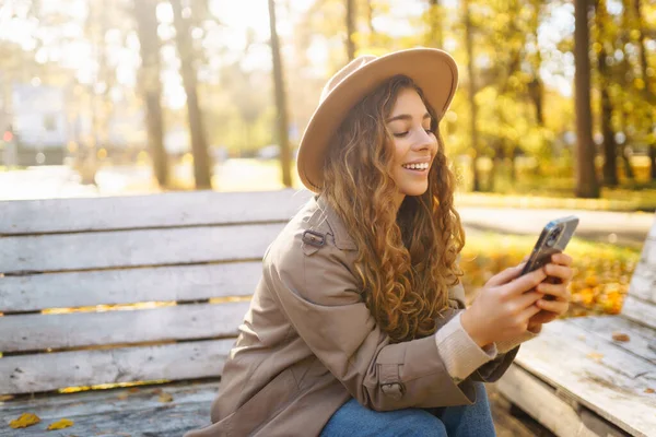Retrato Mujer Feliz Con Teléfono Inteligente Banco Soleado Parque Otoño —  Fotos de Stock