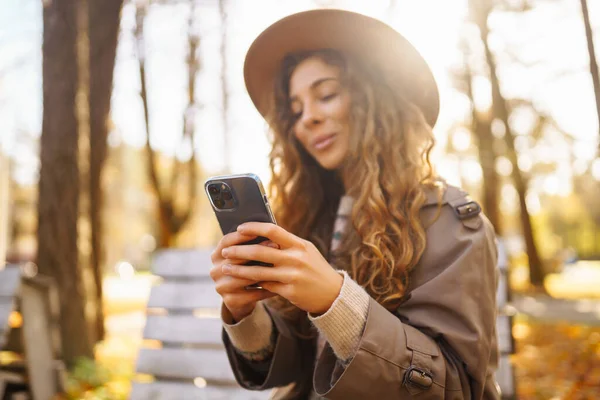 Retrato Mulher Feliz Com Smartphone Banco Ensolarado Parque Outono Mulher — Fotografia de Stock