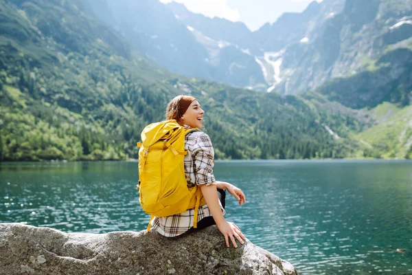 Szczęśliwa Turystka Dużym Żółtym Plecakiem Cieszy Się Widokiem Górskie Jezioro — Zdjęcie stockowe