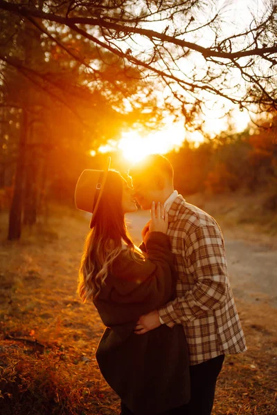 快乐的情侣们穿着休闲装散步 在夕阳下一起穿越秋天的森林 人的概念 生活方式 — 图库照片