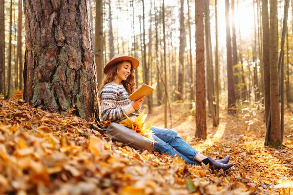 Piękna Kobieta Kręconymi Włosami Książką Rowerze Siedzi Opadłych Liściach Jesiennym — Zdjęcie stockowe