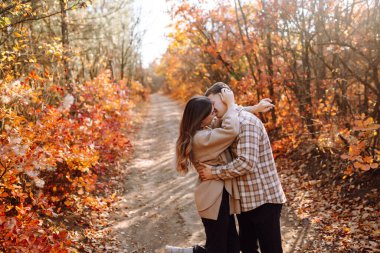 Birbirine aşık çiftler sonbahar parkında dinlenir ve birlikte yürürler. Tarz sahibi erkek ve kadın, sonbahar havasının tadını çıkarırlar. Aşk kavramı, ilişkiler, rahatlama.