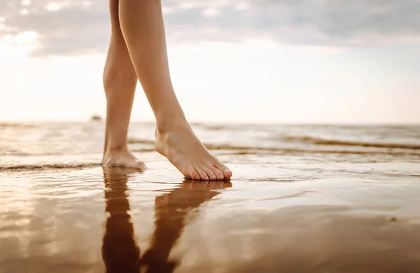 クローズアップした若い女性の足は海水と砂の波をビーチで歩いています 自由の概念 — ストック写真