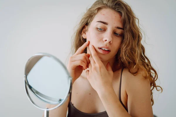 stock image Beautiful woman with problematic skin works in her small mirror. Cosmetology. Skin care concept.